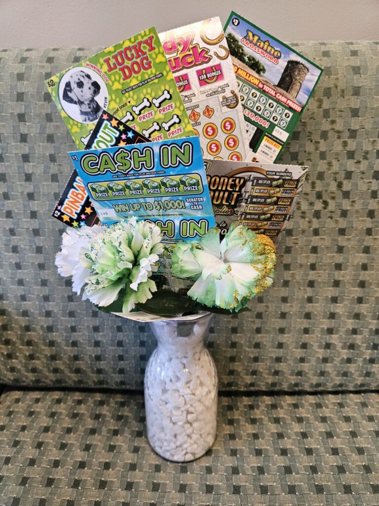 A vase filled with fake flowers and various scratch off lottery tickets.