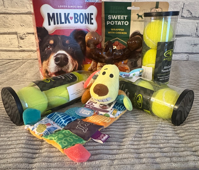 A set of gifts featuring dog toys, treats, and tennis balls.